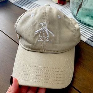 Tan colored Original Penguin hat with leather adjustable strap